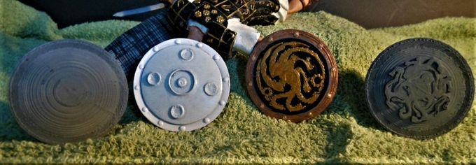 Here is a picture of some of the shields I downloaded from the internet to replace the one that came with the kit shown in white. The shield with the multi-headed dragon (Ghidorah?) was the one I ended up using.