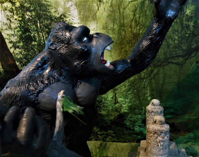 Kong shaking his fist in defiance at the screaming natives on the wall above.